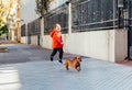 Happy little boy running with his dachshund dog on a city sidewalk Royalty Free Stock Photo