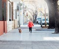 Happy little boy running with his dachshund dog on a city sidewalk Royalty Free Stock Photo