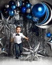 Happy little boy with silver and blue metallic  moon balloons for birthday space party with free tex Royalty Free Stock Photo