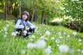 Happy little boy sitting dandelion on spring lawn among dandelion and green grass Royalty Free Stock Photo