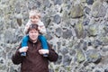 Happy little boy sitting on father's shoulders. Royalty Free Stock Photo