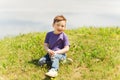 Happy little boy sitting on grass outdoors Royalty Free Stock Photo