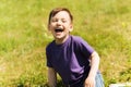 Happy little boy sitting on grass outdoors Royalty Free Stock Photo