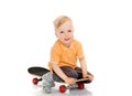 Happy little boy sitting on skateboard Royalty Free Stock Photo