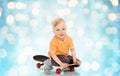 Happy little boy sitting on skateboard Royalty Free Stock Photo