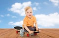 Happy little boy sitting on skateboard Royalty Free Stock Photo