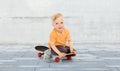 Happy little boy sitting on skateboard Royalty Free Stock Photo