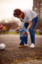 Little boy with soccer ball playing with his mother in a park Royalty Free Stock Photo