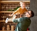 Happy little boy son playing with daddy at home, flying in air in fathers arms Royalty Free Stock Photo