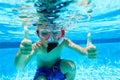 Happy little boy swimming underwater with thumbs up Royalty Free Stock Photo