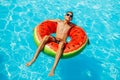 Happy little boy swims with colorful inflatable ring in outdoor pool on hot summer day, Kids toys with water, Kids play in Royalty Free Stock Photo