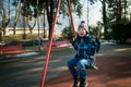 Happy little boy on swing in beautiful winter day Royalty Free Stock Photo