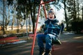 Happy little boy on swing in beautiful winter day Royalty Free Stock Photo