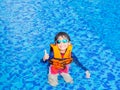 Happy little boy thumbs up with orange life jacket has fun and enjoy in the swimming pool Royalty Free Stock Photo