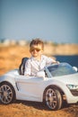 Happy little boy travel by car in summer