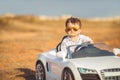 Happy little boy travel by car in summer