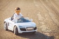 Happy little boy travel by car in summer