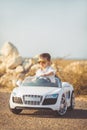 Happy little boy travel by car in summer