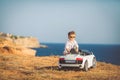 Happy little boy travel by car in summer