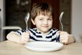 Happy little boy waiting for dinner. Royalty Free Stock Photo