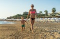 Happy little boy with young beautiful mother running on summer beach. Positive human emotions, feelings, joy. Funny cute child mak Royalty Free Stock Photo