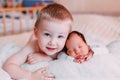 Elder brother and newborn baby sister lying on bed at home Royalty Free Stock Photo