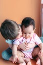 Happy little brother playing hugs his sister baby, boy and girl embraces kisses, concept love and parenting