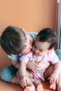 Happy little brother playing hugs his sister baby, boy and girl embraces kisses, concept love and parenting