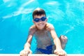 Happy little boy holding edge of swimming pool Royalty Free Stock Photo