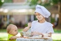 Happy little chef whipping eggs in a bowl outdoors. Royalty Free Stock Photo