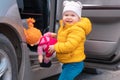 Happy little child assist to her doll sit in the car at children& x27;s backseat. The concept of safe trip and health