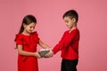 Happy little child boy gives smiling girl a gift box Royalty Free Stock Photo