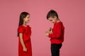 Happy little child boy gives smiling girl a gift box Royalty Free Stock Photo