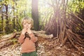 Boy with brushwood pile in forest build hut of branches Royalty Free Stock Photo