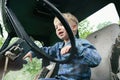 Happy little child boy playing inside old vintage truck car, holding big wheel. Slow life in countryside. Happy childhood concept Royalty Free Stock Photo