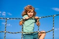 Happy little child boy on the web in outdoor playground. Kid enjoying playing summer activities, kids leisure recreation Royalty Free Stock Photo