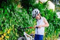 Happy little child boy in white helmet inflating tire in his bicycle Royalty Free Stock Photo