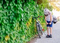 Happy little child boy in white helmet inflating tire in his bicycle Royalty Free Stock Photo