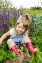 Happy little child with cat. Girl playing  pet outdoors on the garden. Summer nature Royalty Free Stock Photo