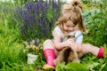 Happy little child with cat. Girl playing with pet outdoors on the garden. Summer nature Royalty Free Stock Photo