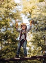 Happy little child climbing on a rope playground outdoor. Cute baby boy playing. Hike and kids concept. Active children