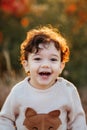 Happy little child, curly hair baby boy laughing and playing in the autumn on the nature walk outdoors Royalty Free Stock Photo