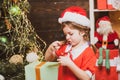 Happy little child dressed in winter clothing think about Santa near Christmas tree. Christmas children. New year and Royalty Free Stock Photo