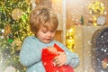 Happy little child dressed in winter clothing think about Santa near Christmas tree. Christmas kids - happiness concept Royalty Free Stock Photo