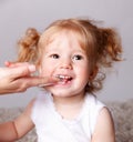 Happy little child getting her teeth brushed with finger toothbrush