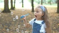 Happy little child girl blowing soap bubbles outside in green park. Outdoor summer activities for children concept Royalty Free Stock Photo