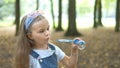 Happy little child girl blowing soap bubbles outside in green park. Outdoor summer activities for children concept Royalty Free Stock Photo