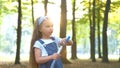 Happy little child girl blowing soap bubbles outside in green park. Outdoor summer activities for children concept Royalty Free Stock Photo