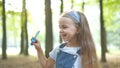 Happy little child girl blowing soap bubbles outside in green park. Outdoor summer activities for children concept Royalty Free Stock Photo