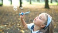 Happy little child girl blowing soap bubbles outside in green park. Outdoor summer activities for children concept Royalty Free Stock Photo